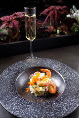 summer soup okroshka with tiger shrimp and fresh cucumber in a black plate