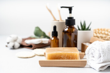 Obraz na płótnie Canvas Natural bathroom and home spa tools. Zero waste sustainable lifestyle concept. Bamboo toothbrush, natural soap bar, cotton pads, homemade DIY beauty products in reusable bottles on white background.