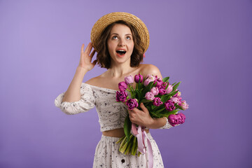 White surprised woman in hat exclaiming while posing with tulips