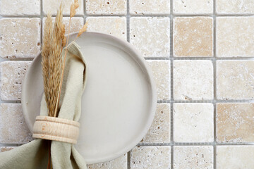 Stylish serving on a travertine mosaic background. Linen napkin on plate. Top view