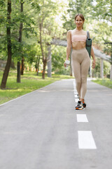 Woman walks through the park in sportswear for training