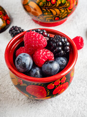 Berry mix in a red wooden mug on a white background .Healthy eating.