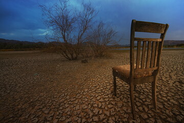 Dry cracked earth and a old chair