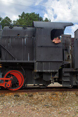 Spanish guy with a black hat and a red shirt on an old train