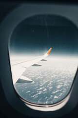 Vista de pajaro desde la ventana de un avion desde donde se ven las nubes en un mar de nubes y el...
