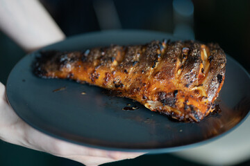Very appetizing and delicious cooked salmon tail on a dark plate. Grilling recipes. Close-up photography of food