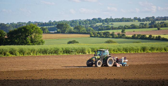 Tracteur au travail dans un paysage champ&ecirc;tre retournant la terre avant les semences.