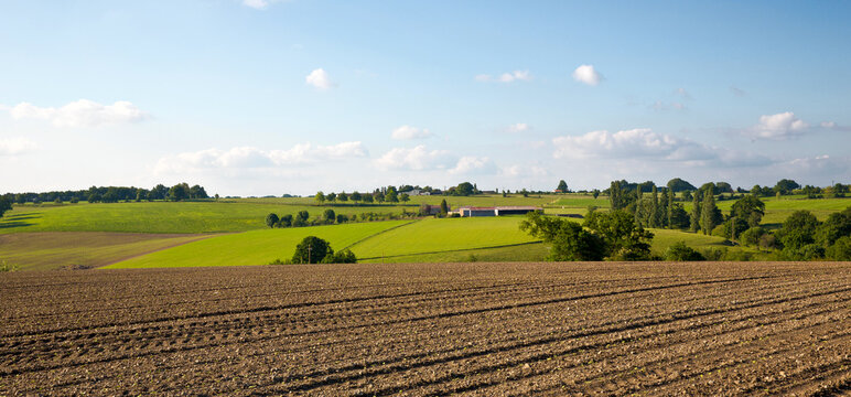 Paysage de campagne avec ses champs fra&icirc;chement retourn&eacute;s par le fermier.