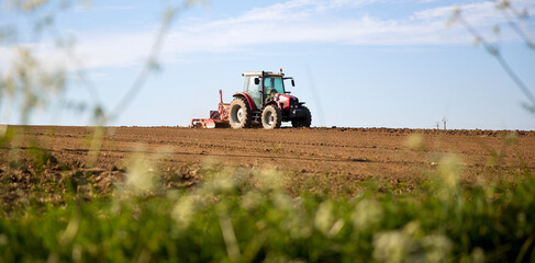 Tracteur labourant les champ de terre au printemps.