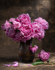 Beautiful bouquet of pink peonies in vase on a wooden table