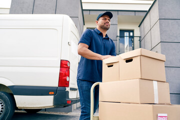 Bottom view of courier carrying packages on a hand truck