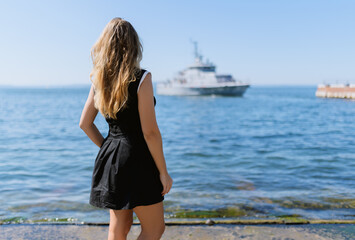 Woman in dress enjoys sea on the pier.