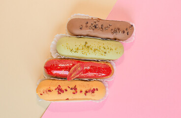 Eclairs on a minimal background. Still life hello dessert mood. Traditional French dessert with colorful icing. Concept baking, cookbook recipes, bakery banner, cafe advertisement.