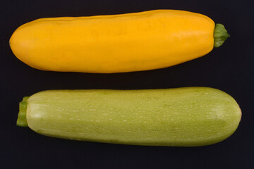 Courgettes blanches Lorea et courgettes jaunes crues sur fond noir