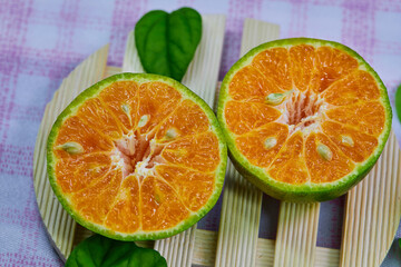 closeup cut of half tangerine isolated on the wooden plate