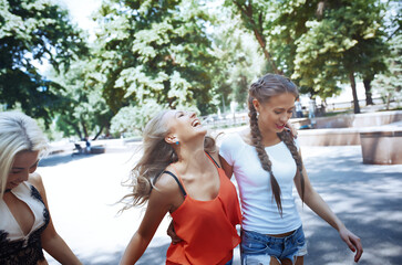 Girlfriends having fun while walking on the sidewalks of downtown