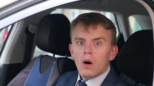 Surprised driver in a car salon, close-up