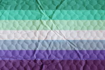 Trans inclusive Gay Mens pride flag on an uneven textured surface.
