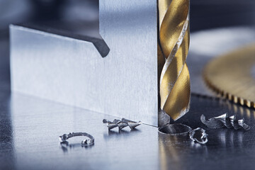 metal drill bit with triangle ruler make holes in steel billet on industrial drilling machine....