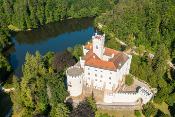 Fototapeta na wymiar Aerial view of Trakoscan castle surrounded by the lake and forested hills, rural Croatia