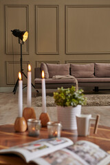 Candle and coffee on the table close up, modern living room background interior.