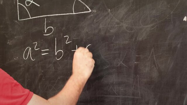 professor writing on a blackboard mathematical equations