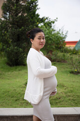 Fototapeta premium Asian Pregnant Woman walking in the park in the morning