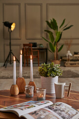 White candle and coffee style on the wood table, decorative working desk background with lamp concept.