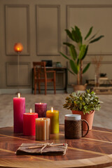 Colorful candle close up concept with coffee wicker glass on the wooden desk, decorative working table computer and chair lamp background.