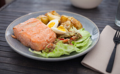 baked salmon fillet with fried potato wedges, homemade guacamole and quail eggs halves