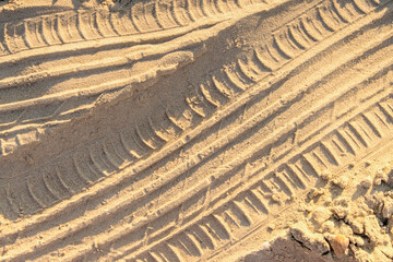 Car footprint pattern on the sand close up.