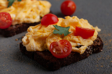 Scrambled eggs with bread and cherry tomatoes on concrete background.  - obrazy, fototapety, plakaty