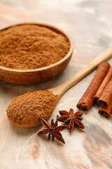 Plate and spoon with cinnamon powder on color background