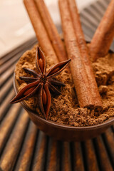 Bowl with aromatic cinnamon on table, closeup