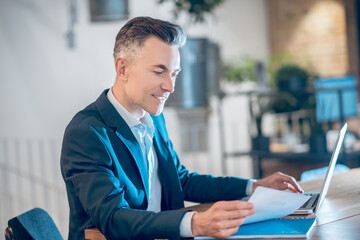 Smiling man in office looking at document