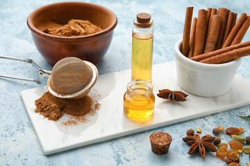 Composition with cinnamon oil, sticks and powder on color background
