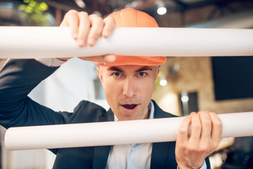 Man in safety helmet with sketches in playful mood