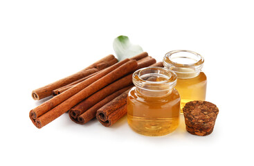 Cinnamon sticks and oil on white background
