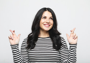Young people, emotion and lifestyle concept: brunette woman made a wish and crossed her fingers