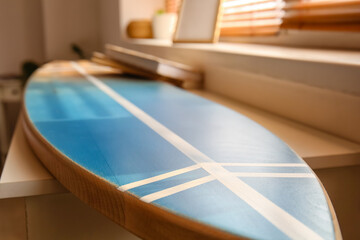 Surfboard near window in room, closeup