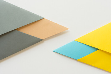 triangle-shaped folded construction paper background in grey sand blue and yellow on white
