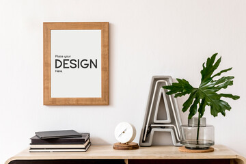 Stylish composition of hall/living room interior design with mock up poster frame, wooden commode and accessories. Template..