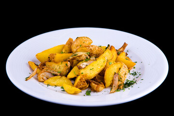 Rustic baked potato slices with onions on a white plate, isolated on a black background