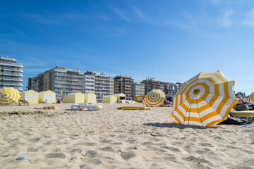 Parasols et cabines de plage jaunes et blancs sur la plage de La Panne
