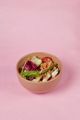 rice and vegetable salad in a deep plate isolated on a solid background