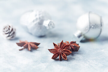 Star anise and Christmas balls on bright wooden background. Close up. 