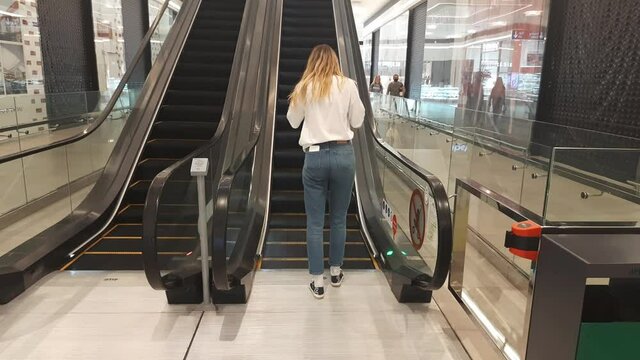 woman walking on escalator
