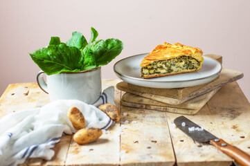 Homemade salty pie filled with potatoes, cheese and spinach