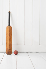 Cricket bat against wall.