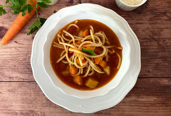 Italian minestrone vegetable soup with bacon, carrots, celery, leek, tomatoes, spaghetti noodles and parmesan.